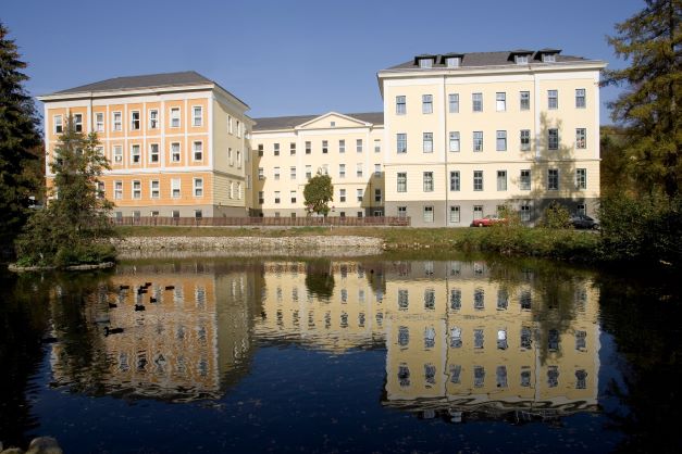 yellow building in front of a pond