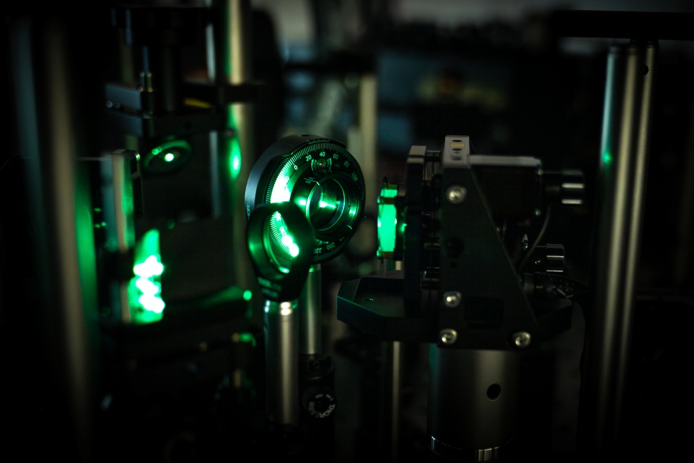 Examining a lead-halide perovskite crystal in the lab using optical methods. The sample glows green.